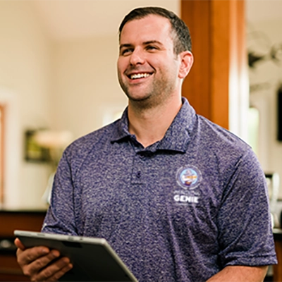 Window Genie service professional smiling and holding clipboard in customer's home.