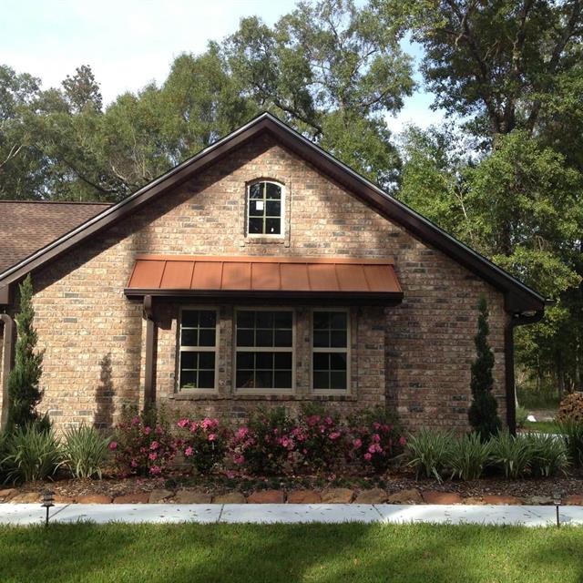 A Brick House with grass yard and gardens