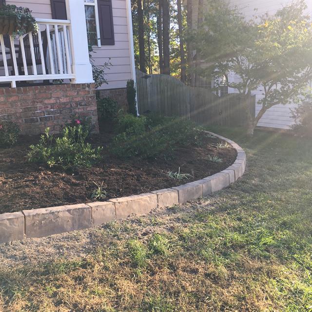A garden landscaped with a stone border.