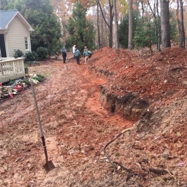 A group of workers work on landscaping work.