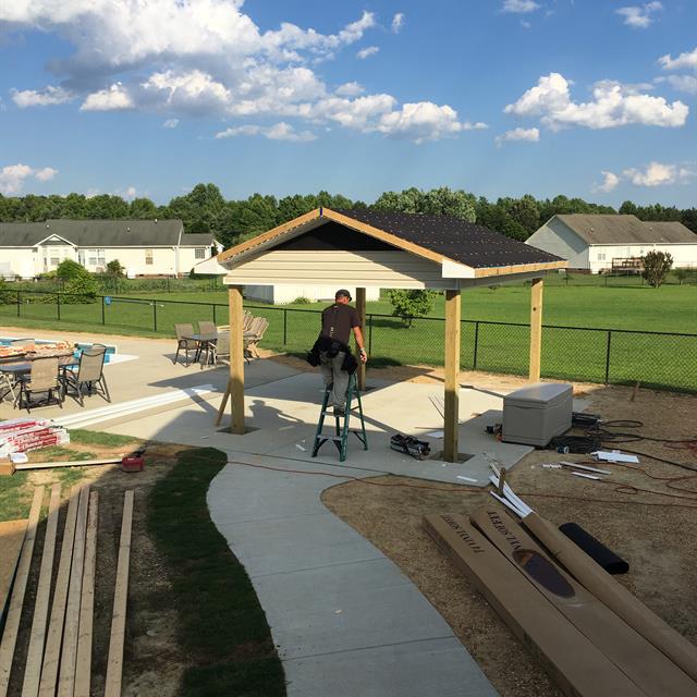 A worker working on a construction near a pool.