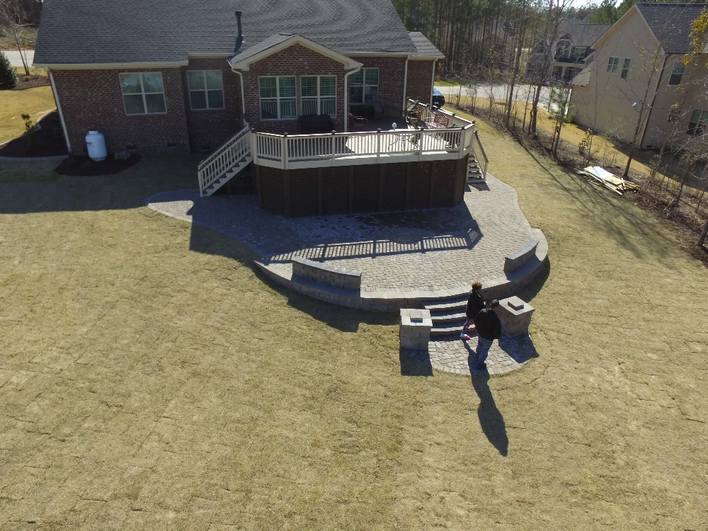 Aerial view of home with second story patio and concrete patio on yard