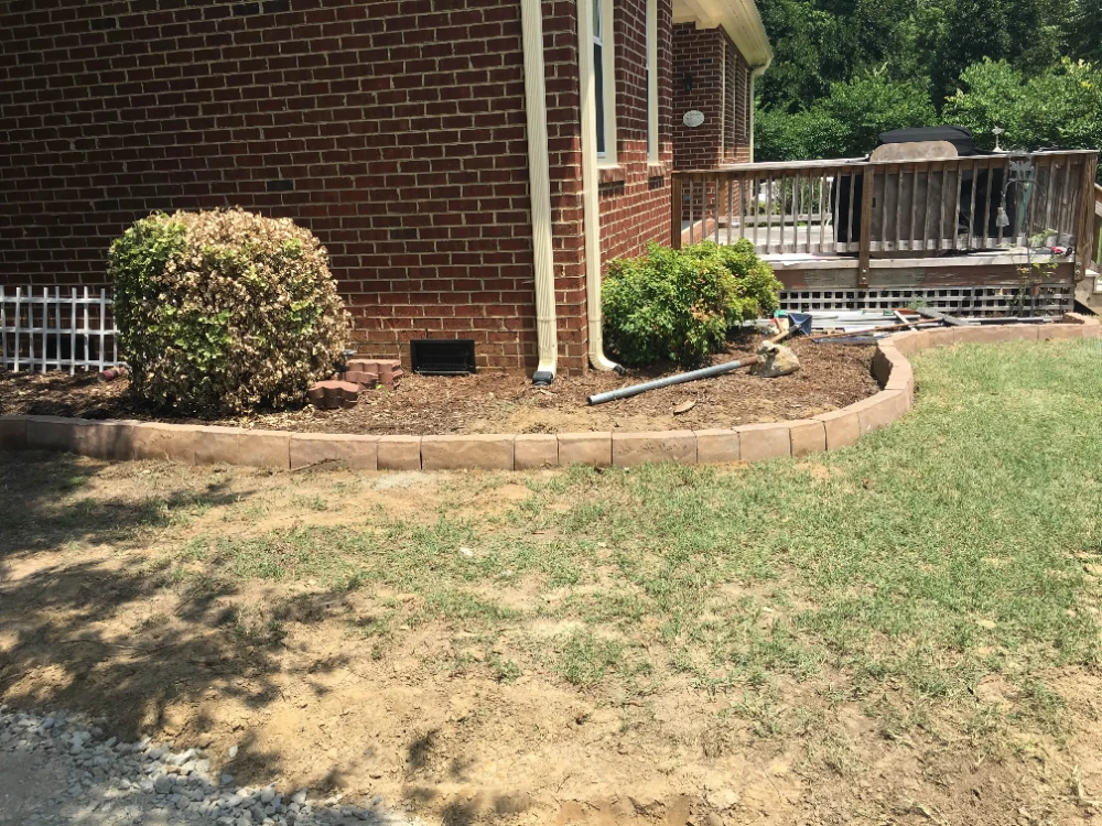 Corner of brick house with yard and construction tools