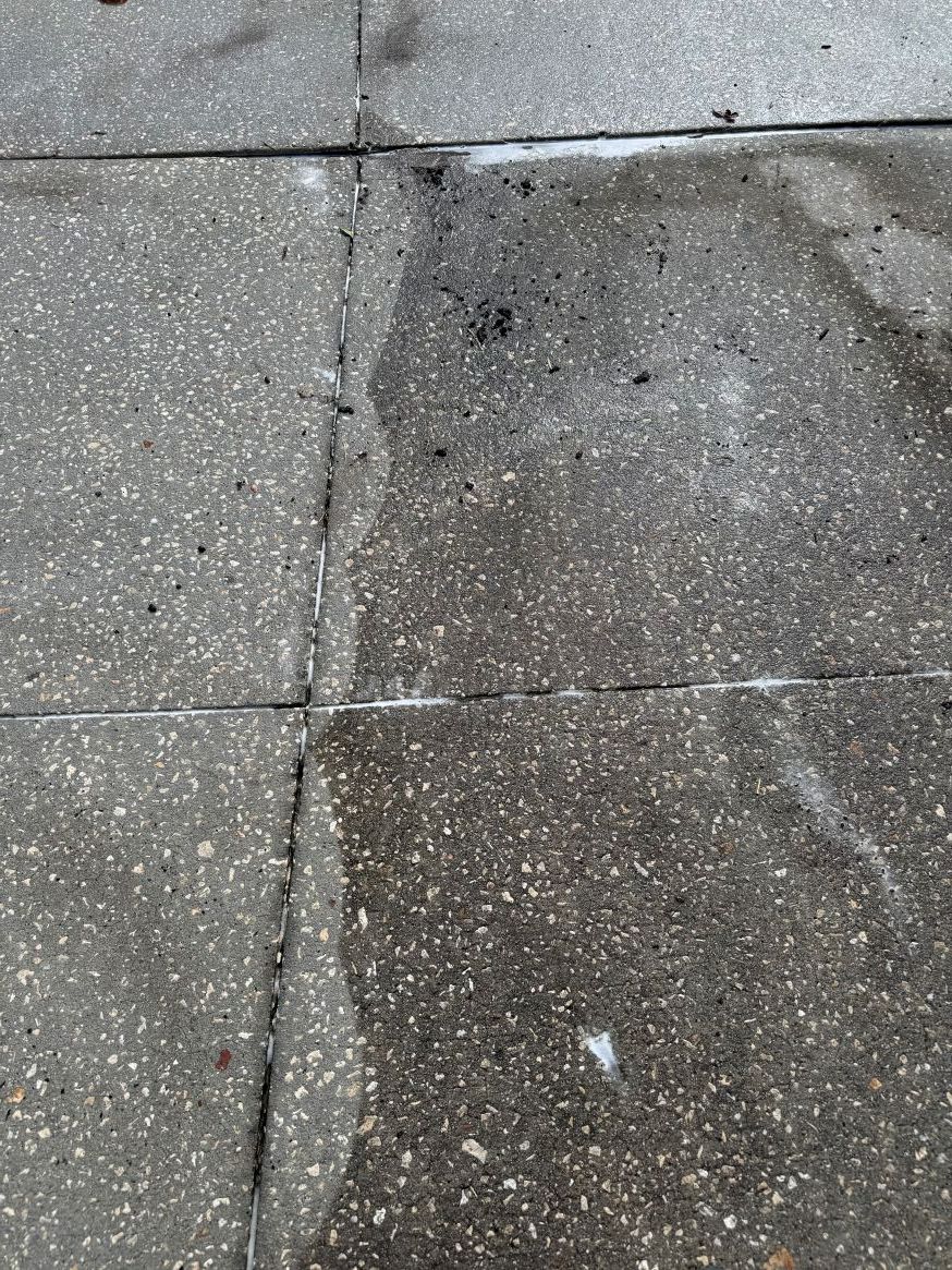 Pressure washing driveway in progress.
