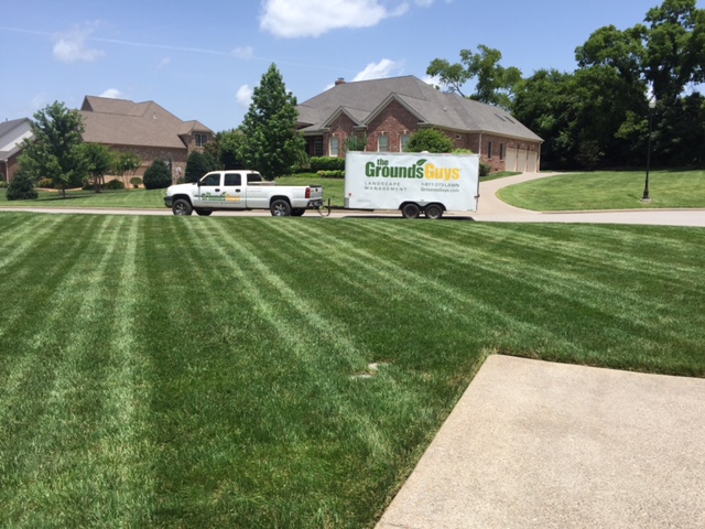 Freshly cut grass lawn with the Grounds Guys truck