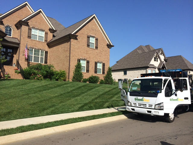 Freshly cut grass lawn with the Grounds Guys truck