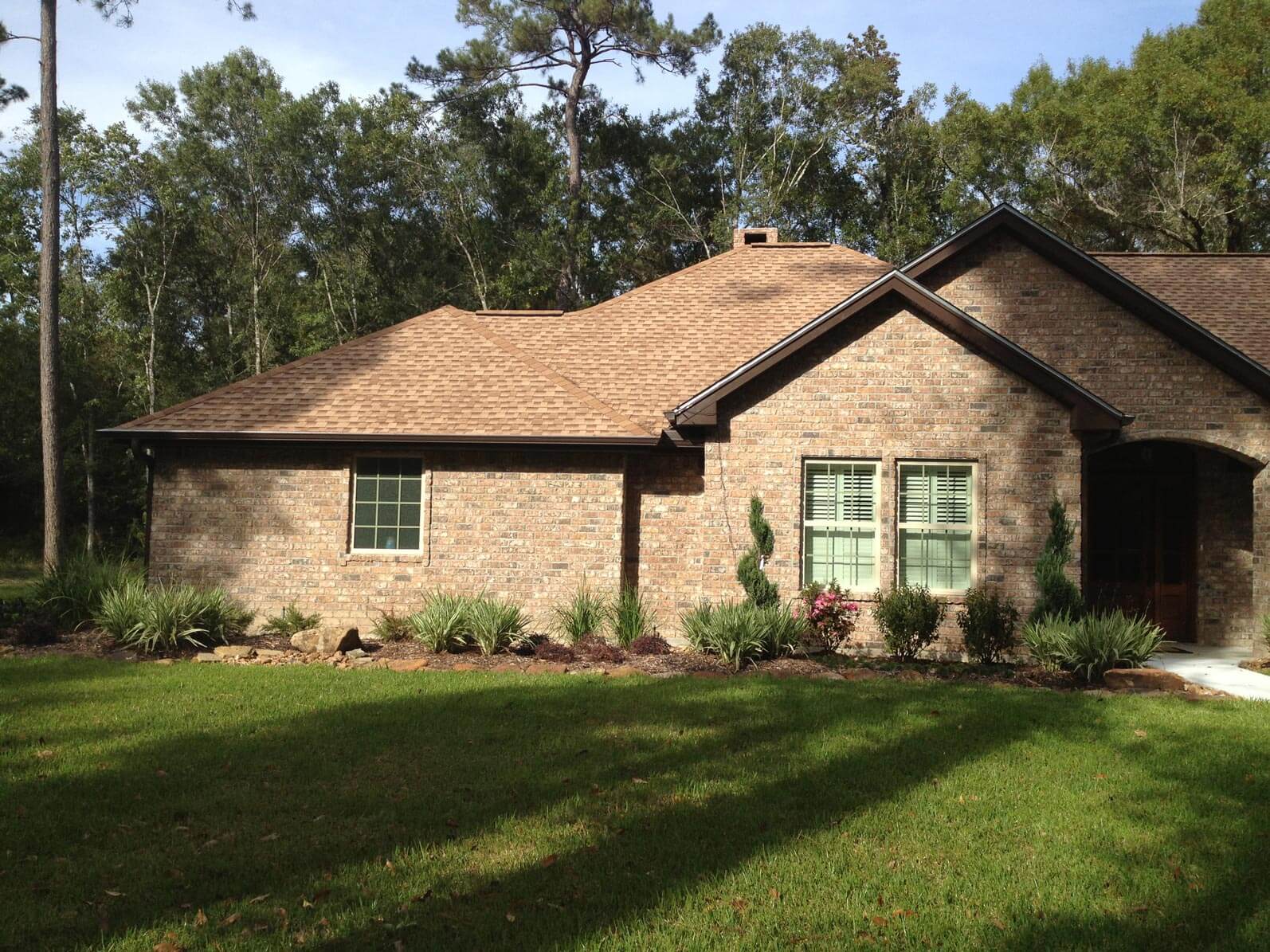 Grass yard in front of brick house