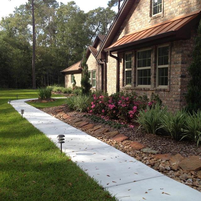 Grass yard with walkway in front of house