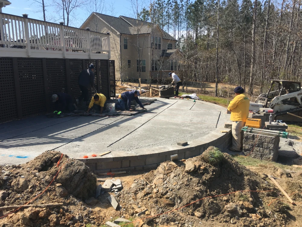 Half moon cement patio in progress with yard workers