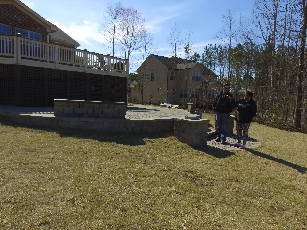 Home with second story patio and concrete patio on yard