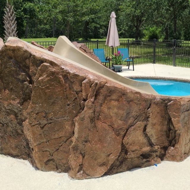 Installation of rock-surrounded slide into inground pool