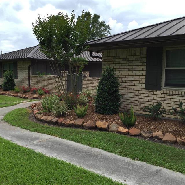 Lawn and stone landscape in front of stone house