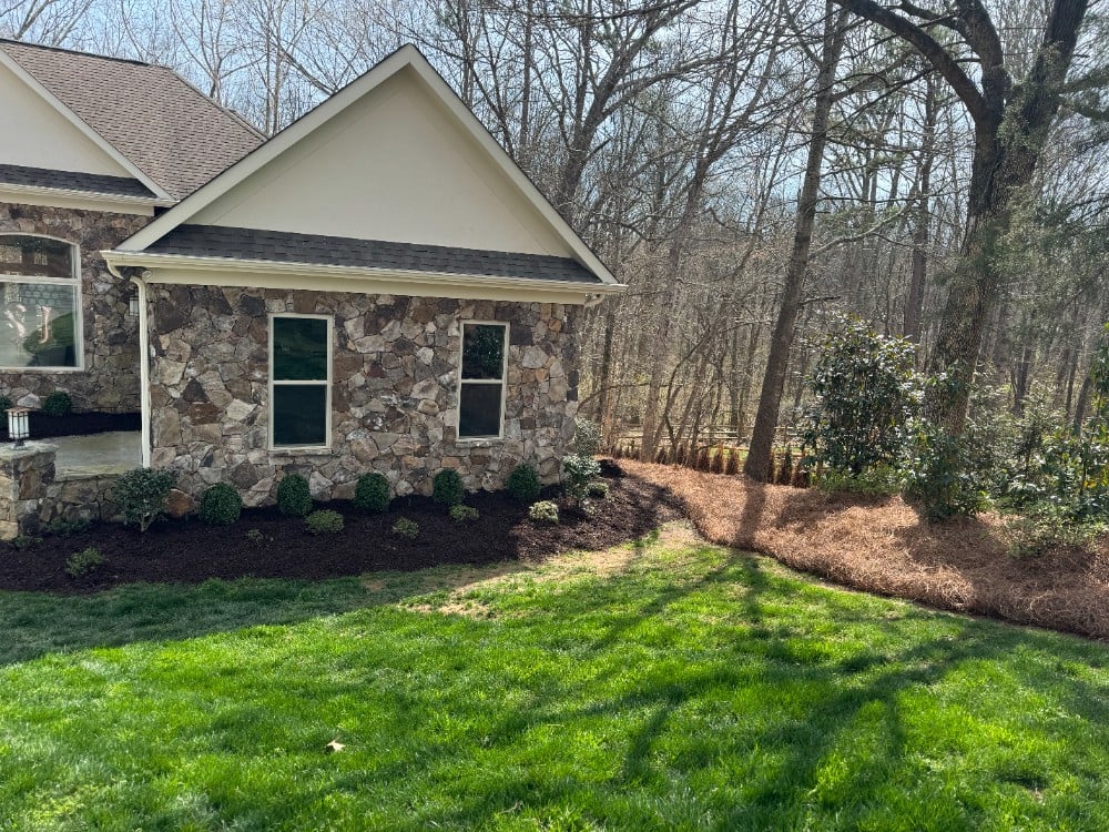 Pine needle and mulching in large beds. Complete with hardy bush accents that add style and easy maintenance.