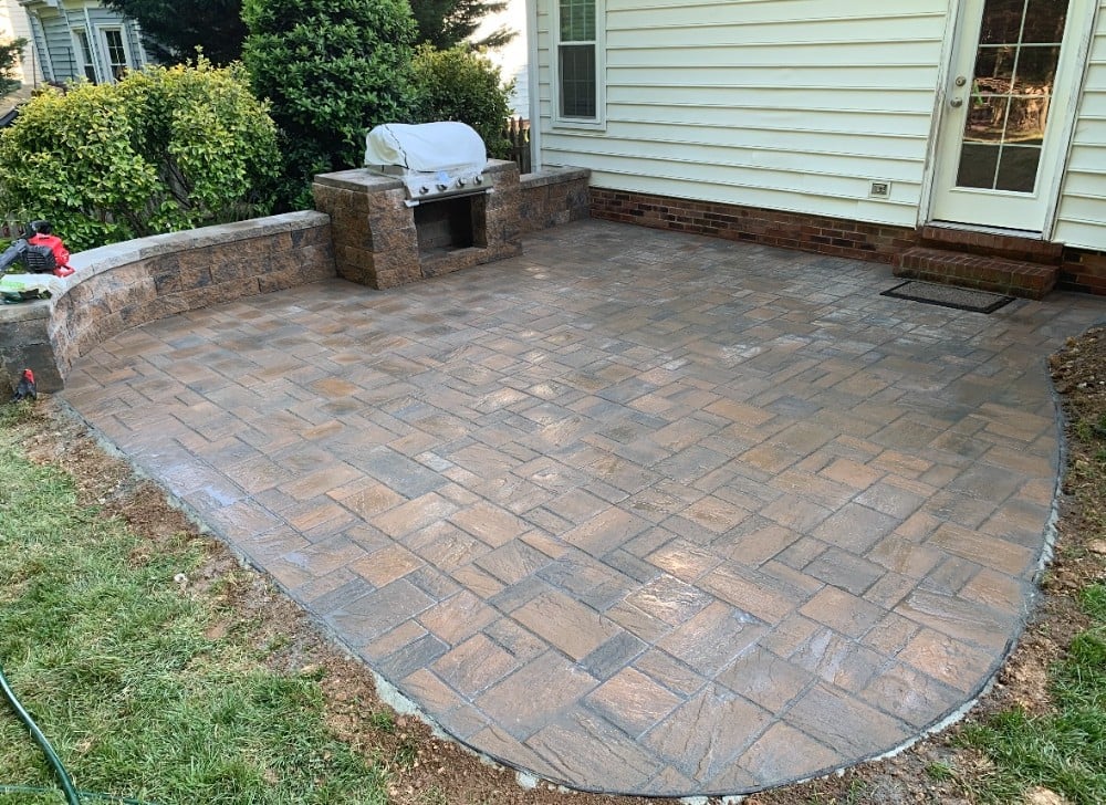 Stunning patio pavers laid in a basketweave pattern over a large area. Also featuring a matching stone wall for barbecue grill housing.