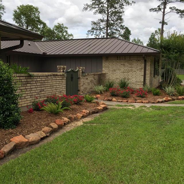 Side view of grass yard in front of brick house