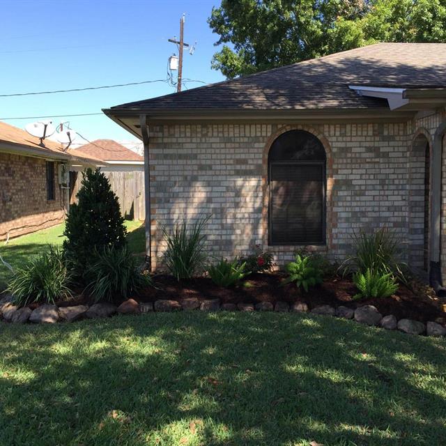 Side view of grass yard in front of brick house