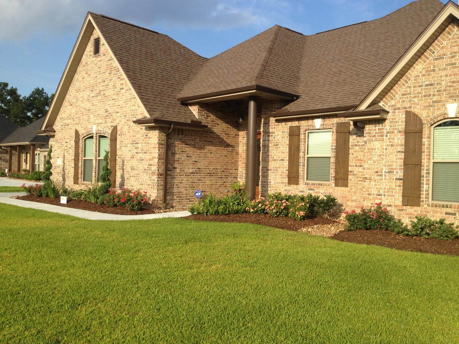 Side view of grass yard in front of brick house