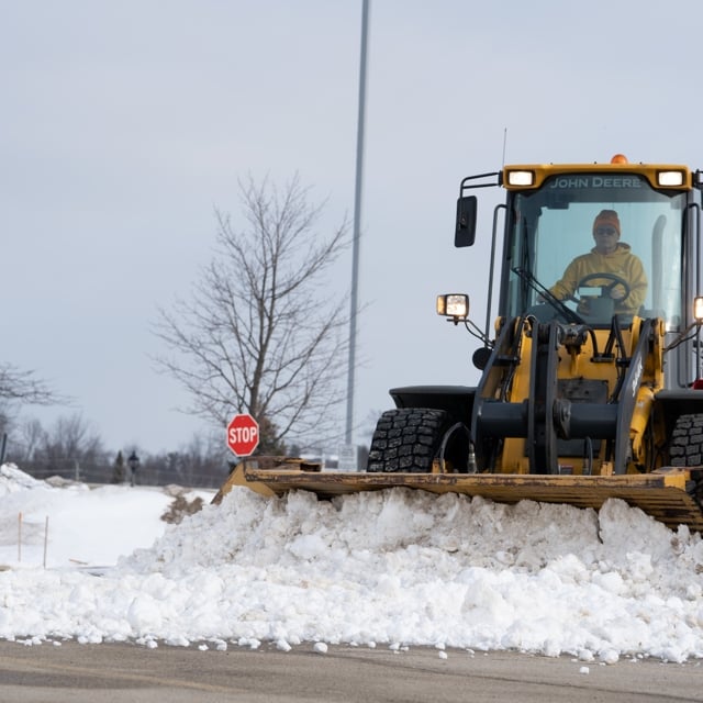 Ground guy employee removing snow using a vehicle