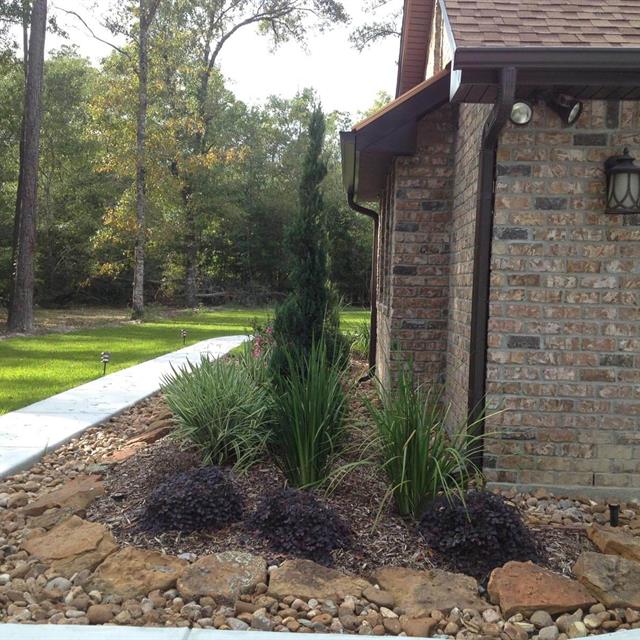Soil and stone landscape on side of brick house