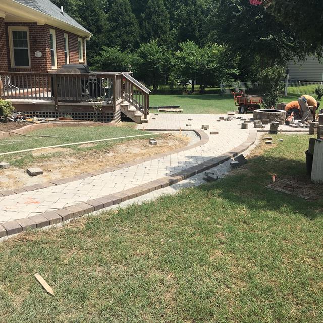 Stone pathway under construction near a patio.
