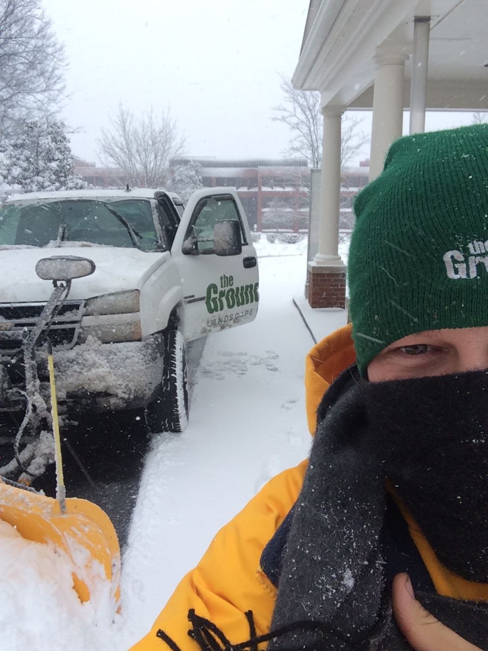 The Grounds Guys in winter gear, clearing snow