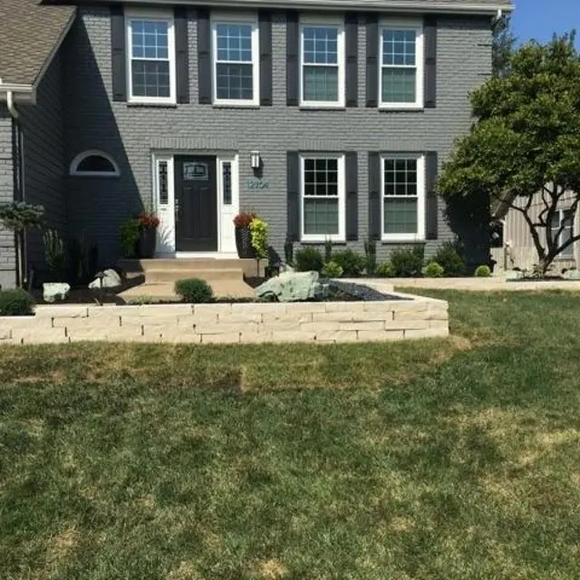 manicured front lawn with raised flower bed