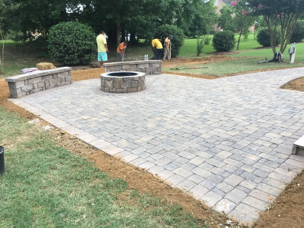 Workers completing the finishing touches on patio and walkway
