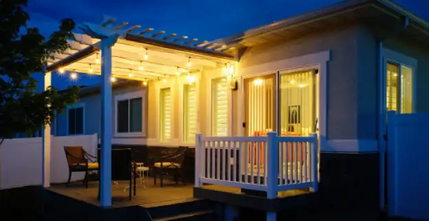 A home's backyard patio lit by string lights.