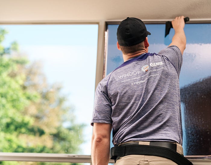 Window Genie technician performing window tinting at a commercial property