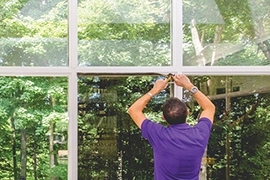 man removing window film.