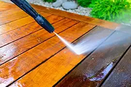 An exterior wood surface being pressure washed.