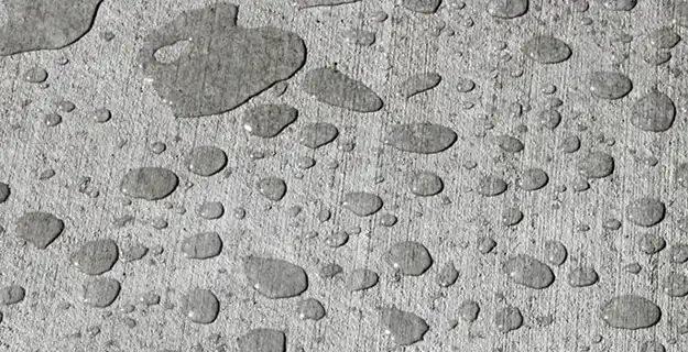 Sealed concrete with drops of water resting on surface.