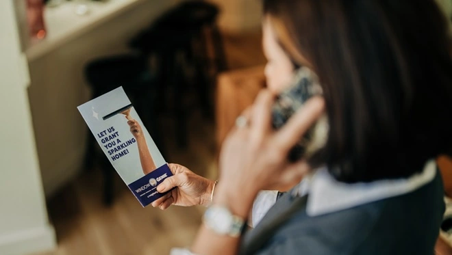 Woman using cell phone to contact her local Window Genie.