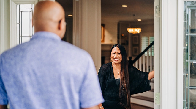 Window Genie customer greeting a technician at the door with a smile on her face.