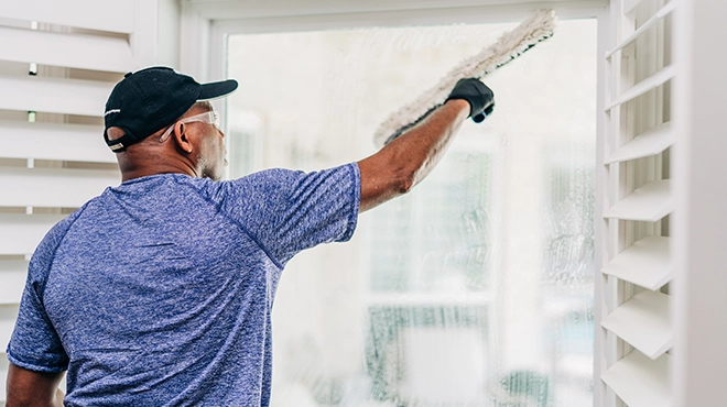 Window Genie service professional cleaning an interior window.