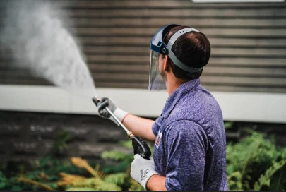Professional-grade pressure washer–surface cleaner being used on the home siding
