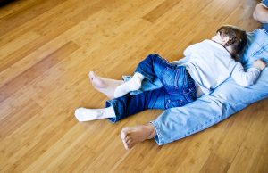 A child lying in a bamboo flooring.