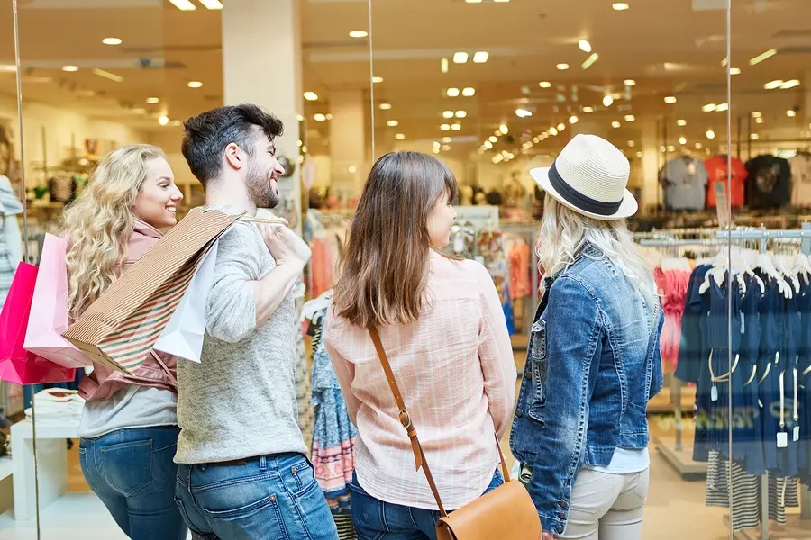 Young people shopping in the mall in front of a fashion shop