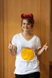 A lady wearing a t-shirt of Devilled egg.