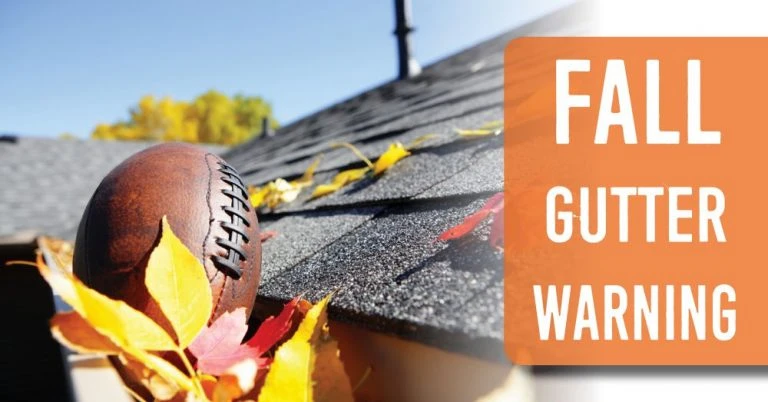 A rugby ball stuck in the gutter on the roof of a house