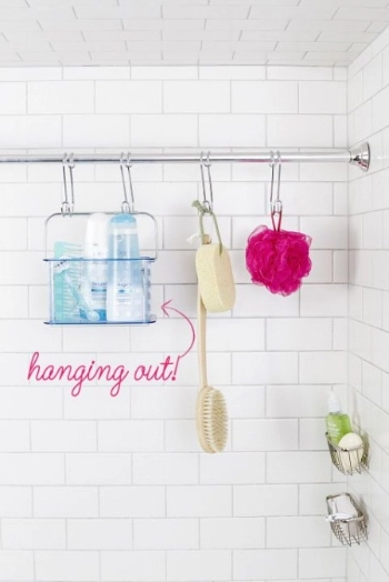 Body cleaning objects hanging on the shower rod in bathroom.