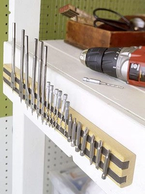 A power drill and screwdriver neatly arranged on a shelf.