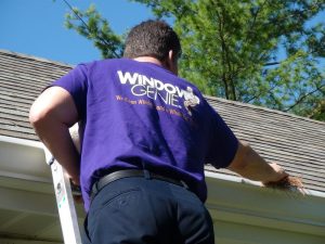 A window genie staff doing gutter cleaning service.