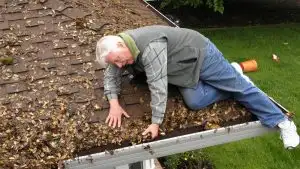 a man cleaning the gutter.