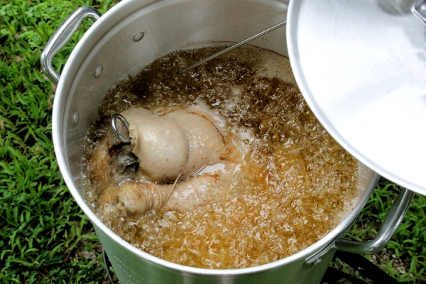 Turkey frying in a large pot of oil.