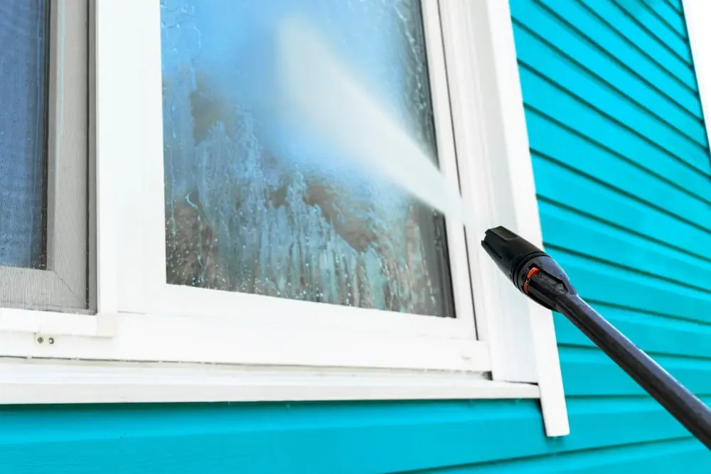 Power washing a house.