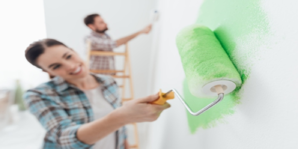 Couple painting the wall couple painting the wall green.