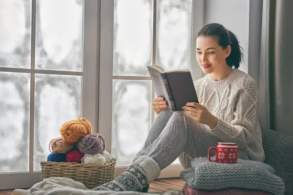 Woman Reading Book in Front of Window.