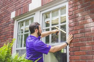 A window genie staff cleaning the window.